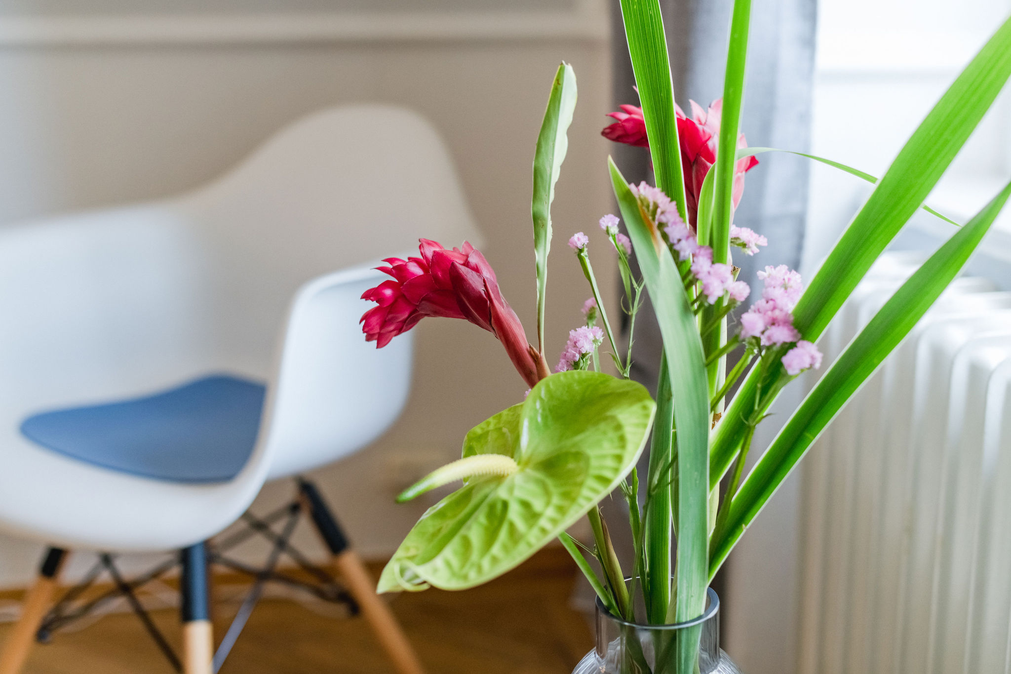 Das Bild zeigt einen Stuhl und einen Blumenstrauß im Wartezimmer.